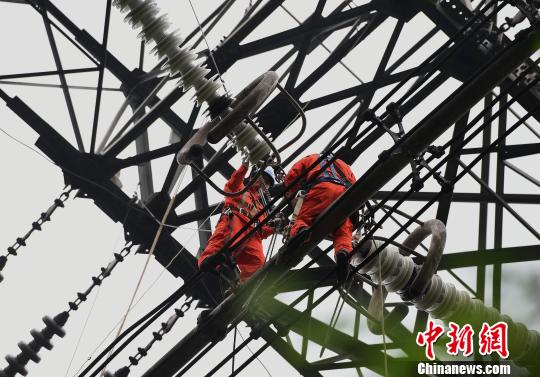 圖為電力工人在70多米高空作業(yè)，為特高壓復(fù)奉線重慶段進(jìn)行八年來首次大修?！≈芤?攝